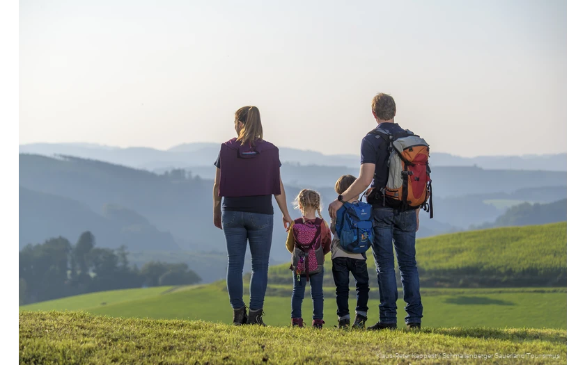 Eine Familie genießt während einer Wanderung im Sauerland die Aussicht auf das Schmallenberger Sauerland.