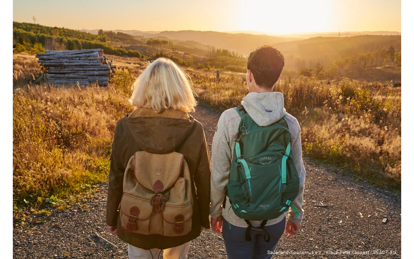 Two female hikers on the Sauerland-Waldroute at sunset.