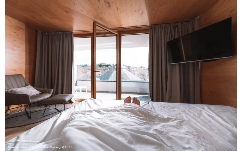 Only the feet look out of a bed with an open window
