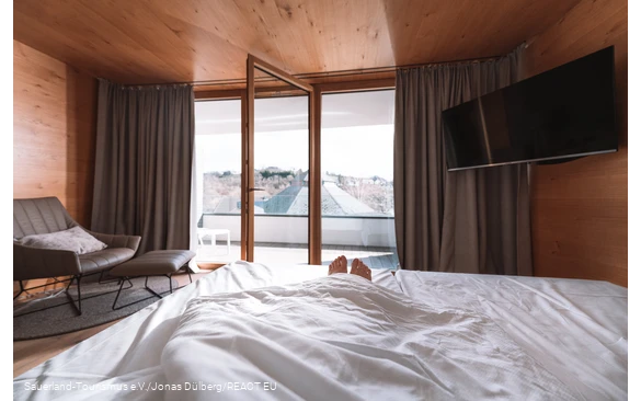 Only the feet look out of a bed with an open window