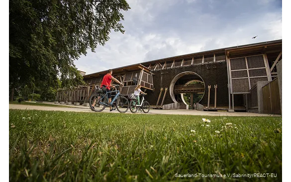 Twee fietsers duwen de fietsen voor het Gradierwerk in Bad Sassendorf