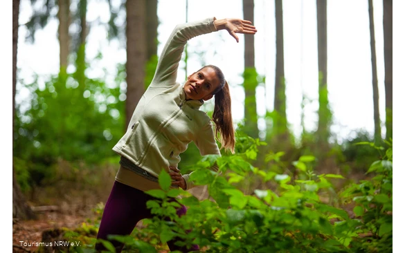 Een vrouw doet een oefening in het bos