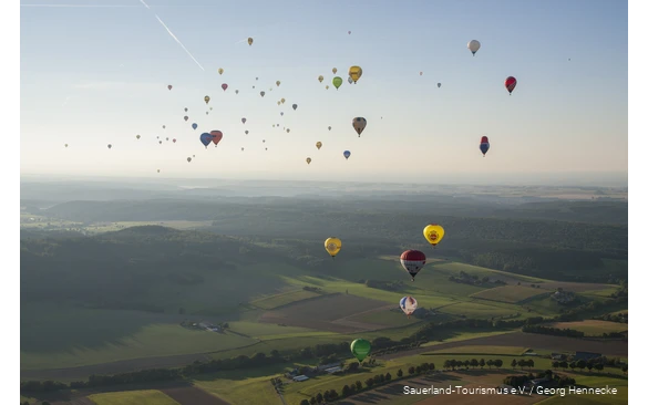 Viele Heißluftballons fliegen über das Sauerland