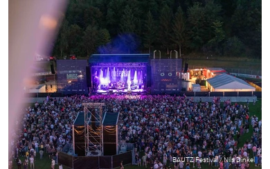 Luftaufnahme von Bautz-Festivalgelände mit großer Bühne und einer Menschenmenge davor