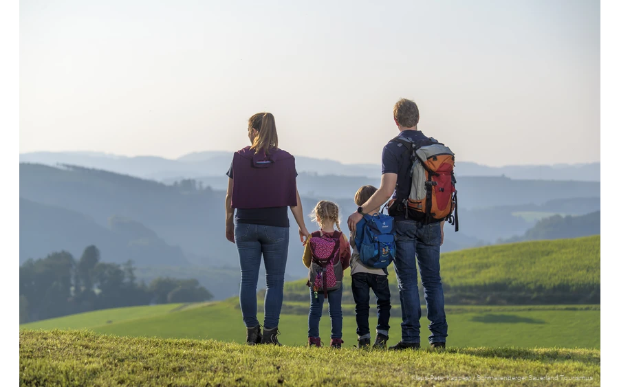 Eine Familie genießt während einer Wanderung im Sauerland die Aussicht auf das Schmallenberger Sauerland.