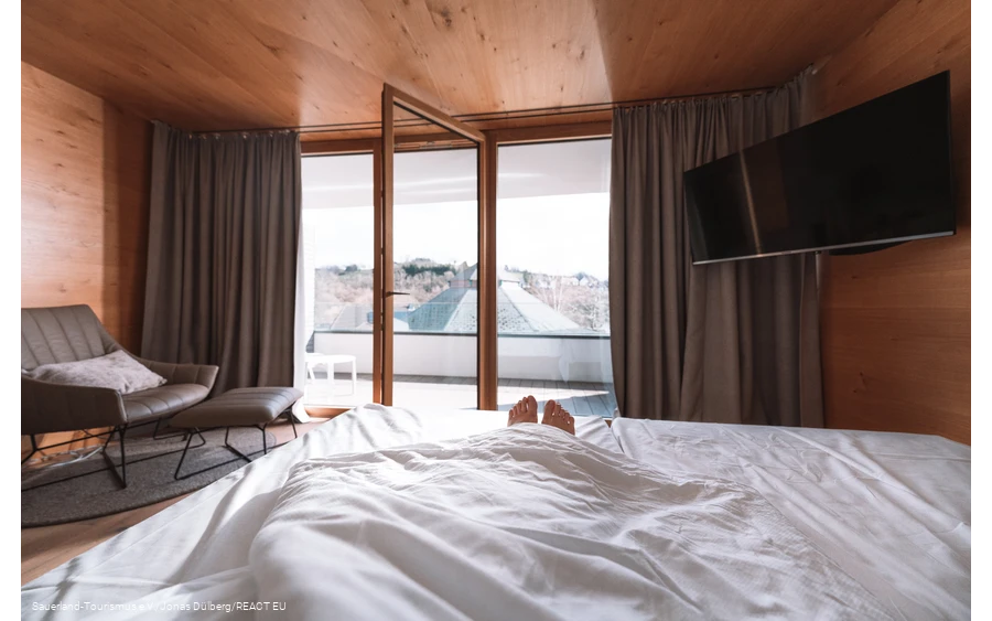 Only the feet look out of a bed with an open window