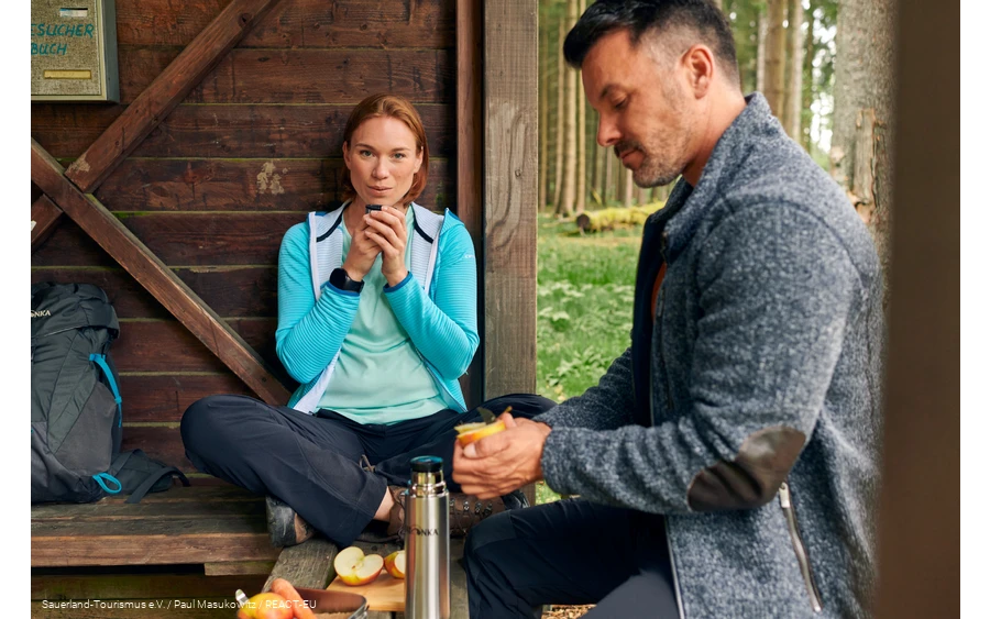 A couple taking a break in a refuge on the Rothaarsteig long-distance hiking trail.