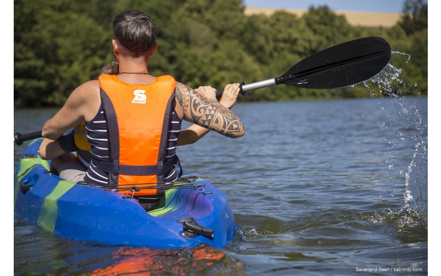 Mann und ein Kind fahren Kanu
