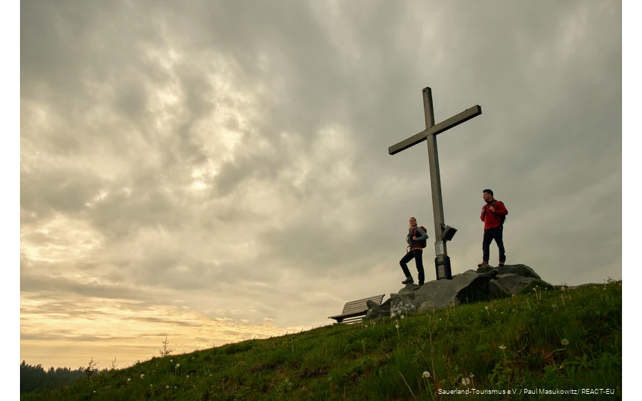 Twee wandelaars genieten van de zonsondergang op de Clemensberg.