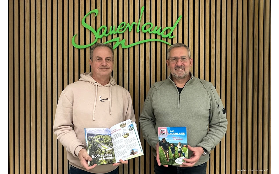 Jürgen Fischbach vom Sauerland-Tourismus und Pascal Möhrke vom Standpunkt-Verlag halten das fertige WAS IST WAS Buch in die Kamera.