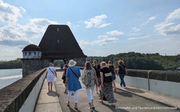 Eine Gruppe Frauen spaziert im Sommer über die Staumauer des Möhnesees.