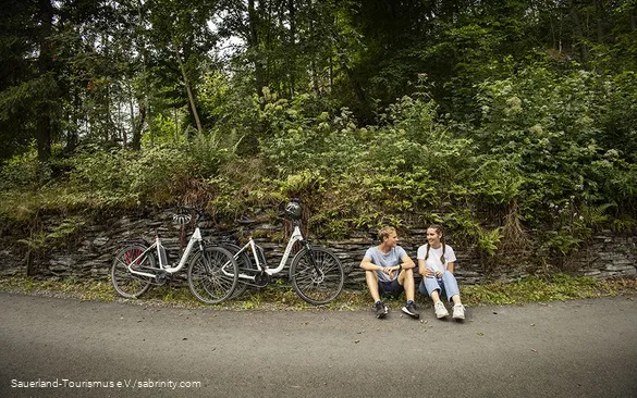 Een paar fietsers nemen een pauze langs de kant van de weg.