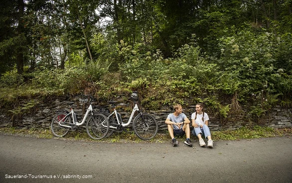 Een paar fietsers nemen een pauze langs de kant van de weg.