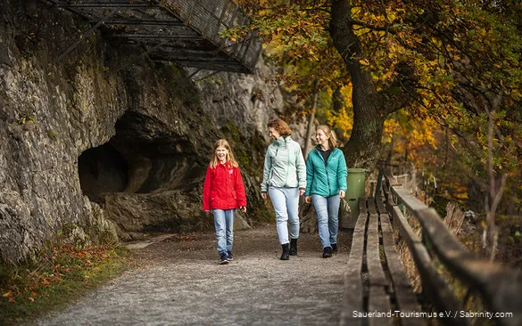 A mother comes out of the Bilstein Cave with her two daughters.