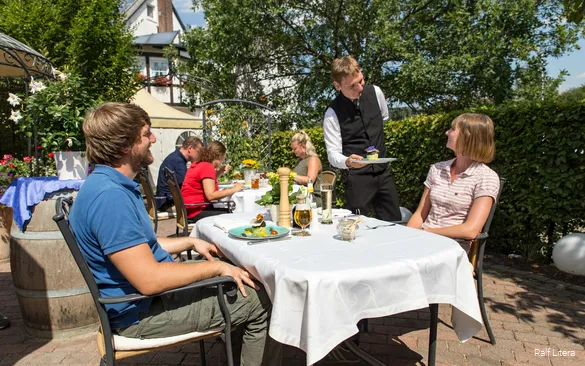 Gasten zitten in de binnentuin van Landgasthof Hoffmann.