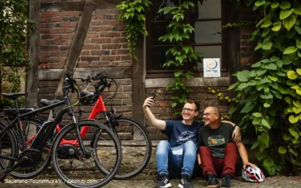 Zwei Radfahrer machen Pause bei einem fahrradfreundlichen Gastgeber.