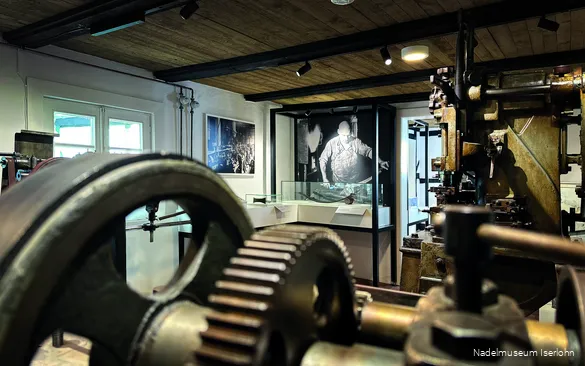 Einlick in das Nadelmuseum Iserlohn mit großen Maschinen, Schaukästen und Fotos.