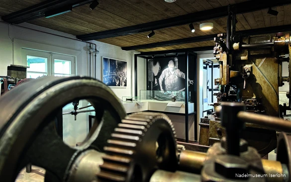 Einlick in das Nadelmuseum Iserlohn mit großen Maschinen, Schaukästen und Fotos.