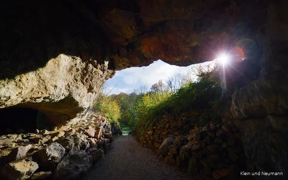 The sun shines into the entrance of the Reckenhöhle.