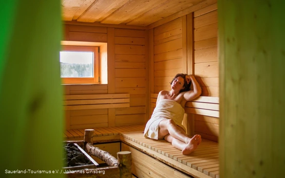 Een vrouw ontspant in de sauna.