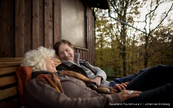 A couple relaxes during a break in an autumnal setting.