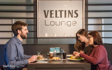 Een groep eet in de Veltins Lounge van de Oversusms in Winterberg.