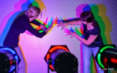 Two women experiment with light and shadow.