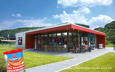 Exterior shot of the Metten factory outlet with a can of Dicken Sauerland Bockwurst in the foreground