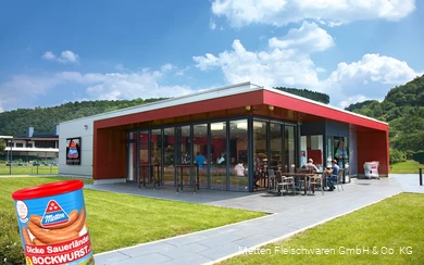 Exterior shot of the Metten factory outlet with a can of Dicken Sauerland Bockwurst in the foreground