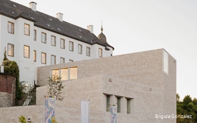 Außenansicht des Erweiterungsbaus des Sauerland-Museums mit Fahnen davor und Schriftzug an der Mauer