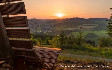 Sonnenuntergang am Hömberg mit Bank im Vordergrund.