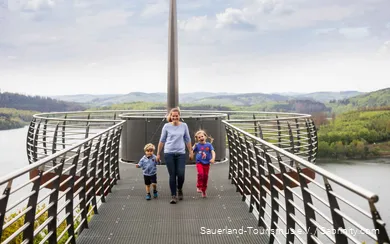 Mother with two children by the hand walking along the Skywalk Biggeblick.