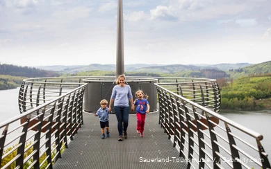Mother with two children by the hand walking along the Skywalk Biggeblick.