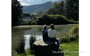 Zwei Personen entspannen im Kurpark TalVITAL in Saalhausen