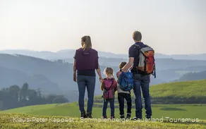 Eine Familie genießt während einer Wanderung im Sauerland die Aussicht auf das Schmallenberger Sauerland.
