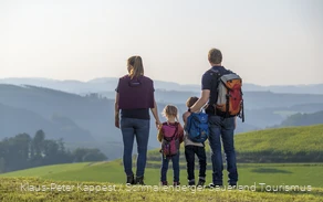 Eine Familie genießt während einer Wanderung im Sauerland die Aussicht auf das Schmallenberger Sauerland.