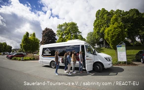 Een groep vrienden stapt in de minibus.