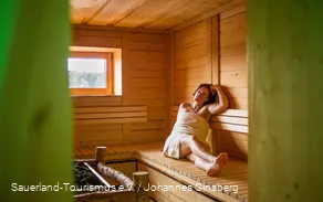 Een vrouw ontspant in de sauna.