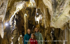 Familie besichtigt eine Höhle im Sauerland