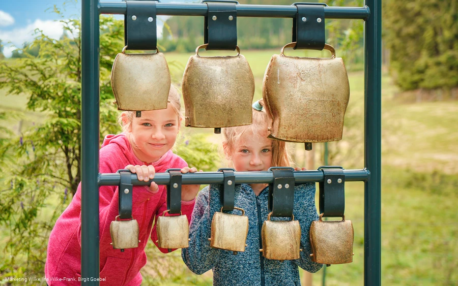 Kinder am Kuhglockenspiel auf dem Milch-Erlebnispfad Usseln