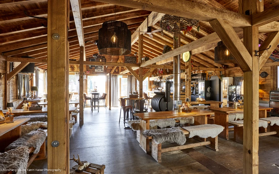 Der Innenraum einer gemütlichen hölzernen Hütte mit einigen Sitzmöglichkeiten.