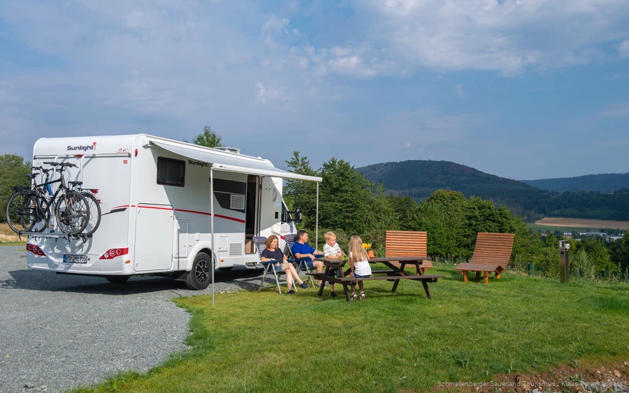 A family enjoys their camping vacation in the countryside.