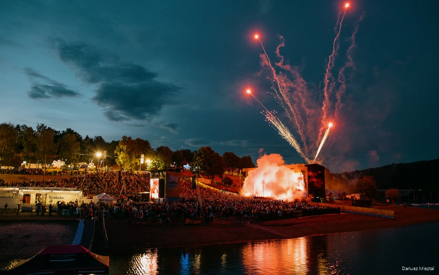 Die Bühne beim Biggesee Open Air in der Dämmerung mit einer großen Menschenmenge und Feuerwerk.