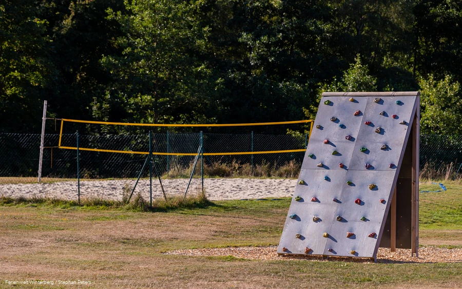 Kletterwand mit Volleybalfeld im Hintergrund. Kletterwand mit Volleybalfeld im Hintergrund.