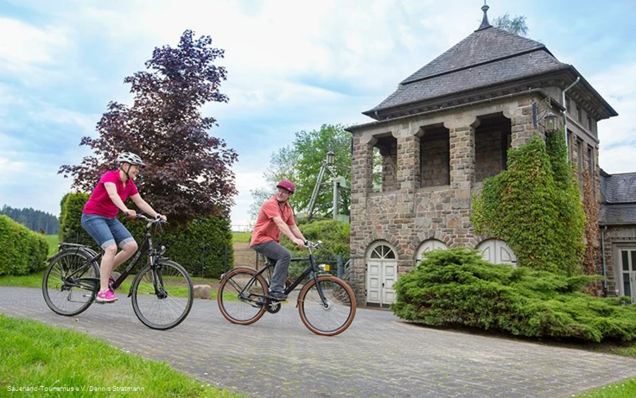 Zwei Radfahrer vor dem Kraftwerk in Finnentrop.