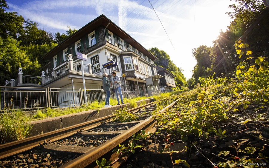 Twee vrouwen staan op het station van Dechenhöhle.