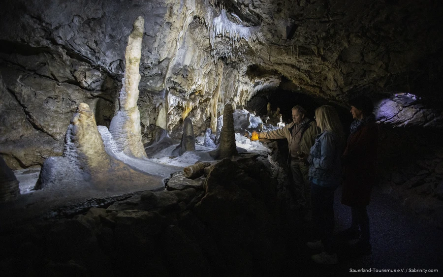Heinrichshöhle 2 De grotgids verlicht een stalactiet met een zaklamp.
