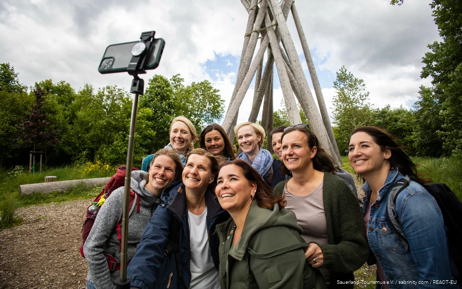 Een groep vrouwen staat voor de Kyrill-Tor in Brilon en poseert voor een selfie.