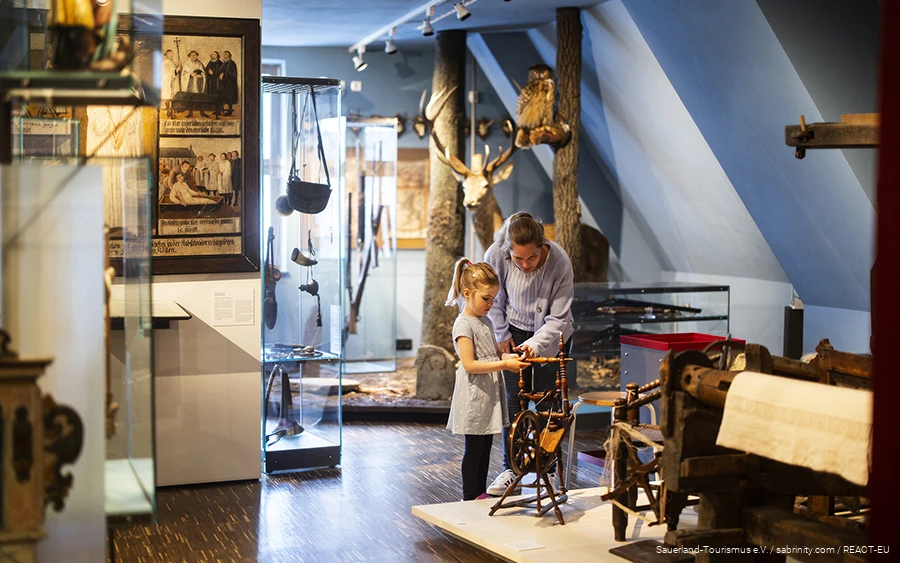 A mother and her daughter look at a spindle in the Südsauerlandmuseum in Attendorn.