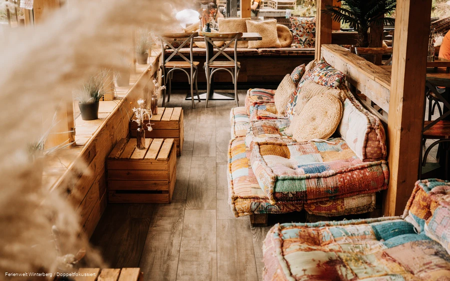 Ein gemütlicher Sitzbereich mit Sofas und kleinen Holzkisten als Tischen.